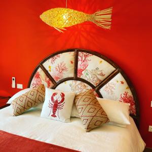 a bedroom with a red wall and a bed with pillows at Sotto le stelle ...il mare in Pietra Ligure