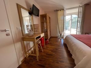 a bedroom with a bed and a desk with a mirror at Sotto le stelle ...il mare in Pietra Ligure