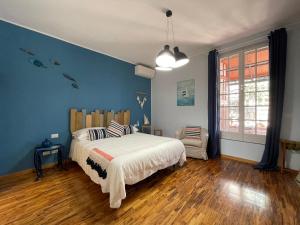 ein Schlafzimmer mit einem Bett und einer blauen Wand in der Unterkunft Sotto le stelle ...il mare in Pietra Ligure