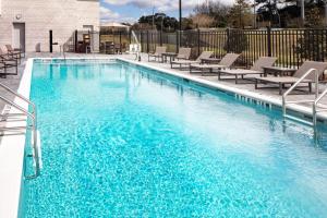 a swimming pool with blue water and lounge chairs at Hyatt House Tallahassee Capitol University in Tallahassee