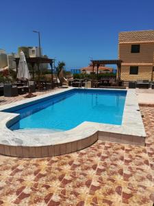 einen Pool in einem Resort mit Fliesenboden in der Unterkunft Chalet 3 VILLA114 first floor 2bed rooms and 2 bathrooms sea view green beach in El-Alamein