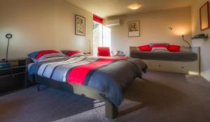 sypialnia z 2 łóżkami z czerwonymi i niebieskimi poduszkami w obiekcie B & B De Stijl w mieście Vessem