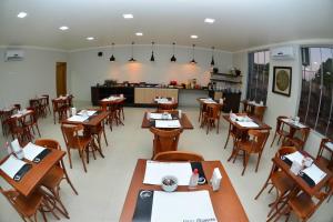 an empty restaurant with wooden tables and chairs at Hotel Mandino in Alta Floresta