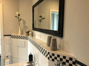 a bathroom with a mirror and a sink at Lykkehus in Humptrup