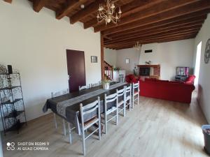 a dining room with a long table and chairs at la longere de Lor'Phée in Chantepie