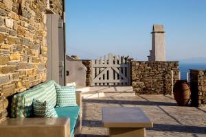 a patio with a bench and a gate and the ocean at Villa Adele in Arnados