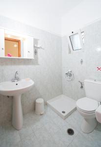 een witte badkamer met een wastafel en een toilet bij Kalamaras Studios in Laganas