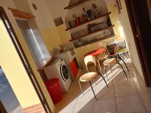 フルナリにあるB&B Pinna Giallaのキッチン(洗濯機、いくつかの椅子付)