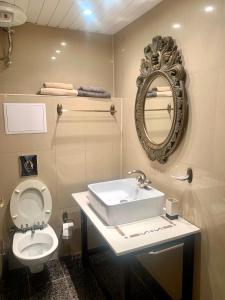 a bathroom with a sink and a toilet and a mirror at Tsar Simeon Veliki in Stara Zagora