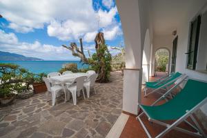 a patio with a table and chairs and the ocean at Casa Sabrina in Portoferraio