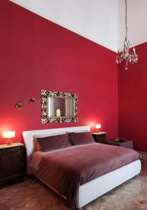 um quarto vermelho com uma cama e um espelho em Chez Moi Charme B&B em Lecce