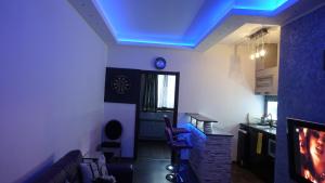 una sala de estar con una luz azul en el techo en Apartament Neon, en Gdynia