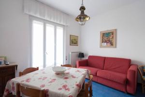 Una sala de estar con un sofá rojo y una mesa. en Relax immersi nella natura, en Monterosso al Mare