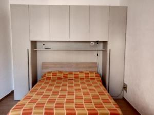 フルナリにあるB&B Pinna Giallaの白いキャビネットが備わる小さな部屋のベッド1台分です。