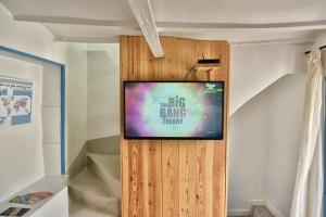 einen Flachbild-TV an der Wand in einem Zimmer in der Unterkunft Charmante Maison indépendante dans le vieux calpe in Calpe