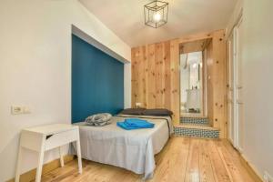 Schlafzimmer mit einem Bett, einem Tisch und einem Spiegel in der Unterkunft Charmante Maison indépendante dans le vieux calpe in Calpe