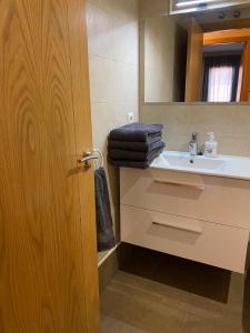 y baño con lavabo y espejo. en Apartamento del pirineo, en Salas Bajas