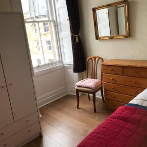 ein Schlafzimmer mit einem Bett, einer Kommode und einem Stuhl in der Unterkunft Apartment Newington Area in Edinburgh