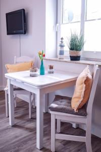 un tavolo bianco con sedie in una camera con TV di Flippi-s-Hues-OST a Westerland