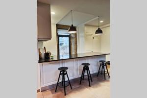 a kitchen with a counter and two stools at Villa Tauria- Casa de campo em aldeia medieval in Sabugal