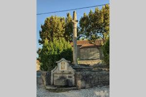 a stone fountain in front of a house at Villa Tauria- Casa de campo em aldeia medieval in Sabugal