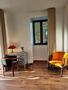 a room with a chair and a desk and a window at Villa Tauria- Casa de campo em aldeia medieval in Sabugal