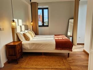 a bedroom with a large bed and a mirror at Villa Tauria- Casa de campo em aldeia medieval in Sabugal