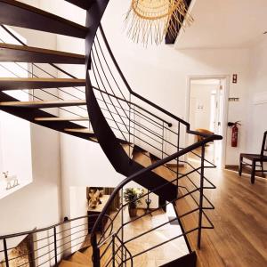 a spiral staircase in a living room with a chandelier at Villa Tauria- Casa de campo em aldeia medieval in Sabugal