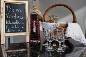 a table with wine glasses and a basket and a chalkboard at Villa Tauria- Casa de campo em aldeia medieval in Sabugal