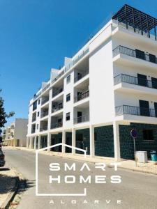 a white apartment building with the words smart homes adaptive at Modern 2Bed Rooftop Pool & Gym, Marina &Meia Praia Lagos in Lagos