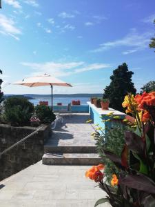 - une terrasse avec un parasol et quelques fleurs dans l'établissement Apartments & Rooms Matos, à Portorož