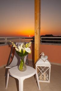 a vase of flowers sitting on a table next to a chair at Affittacamere a due passi dal mare in Marina di Cecina