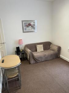 a living room with a couch and a table at No 7 - 1 BED NEAR SEFTON PARK AND LARK LANE in Liverpool