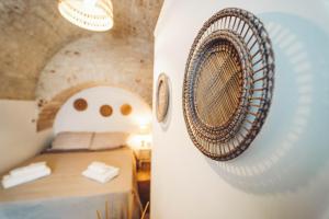 Habitación con cama y tabla de surf blanca en Trullo Syrah-Trulli Antì Charme & Relax en Alberobello