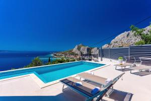 a villa with a swimming pool and views of the ocean at Villa Belvedere with heated pool, billiards, Media room, sea views,10 pax in Omiš