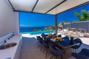 a kitchen and dining room with a view of the ocean at Villa Belvedere with heated pool, billiards, Media room, sea views,10 pax in Omiš