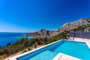 a swimming pool with a view of the ocean at Villa Belvedere with heated pool, billiards, Media room, sea views,10 pax in Omiš