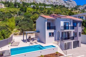 an image of a villa with a swimming pool at Villa Belvedere with heated pool, billiards, Media room, sea views,10 pax in Omiš