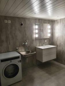 ein Badezimmer mit einer Waschmaschine und einem Waschbecken in der Unterkunft Hus sentralt i Lofoten in Leknes