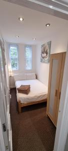 a small bedroom with a bed and a mirror at No 7 - 1 BED NEAR SEFTON PARK AND LARK LANE in Liverpool