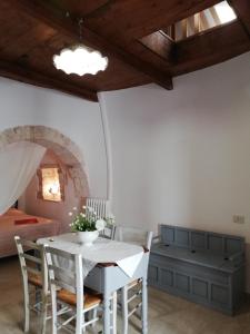 a room with a table and chairs and a bed at Luxury Trulli sabotino 61 in Alberobello +43 photos