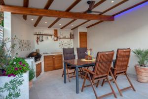 cocina con mesa de madera y sillas en Idyllic villa Marieta with private pool and unforgettable view, en Makarska