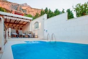una piscina con patio y una casa en Idyllic villa Marieta with private pool and unforgettable view en Makarska