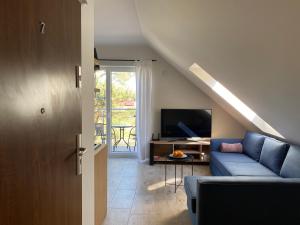 a living room with a blue couch and a tv at Apartament w Dębkach in Dębki