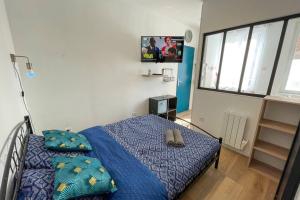 - une chambre avec un lit doté d'une couette et d'oreillers bleus dans l'établissement Studio Spa Privatif NETFLIX Unique Amiens, à Amiens