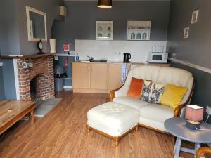 a living room with a couch and a kitchen at The Snooty Fox in Looe