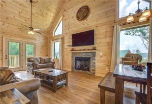 a living room with a fireplace in a log cabin at Walnut Ridge Cabin. Sleeps 7-11! Hot tub, pool table, minutes to downtown Gatlinburg! in Gatlinburg