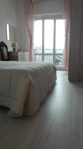 um quarto com uma cama e uma grande janela em Casa di Alessio, 6 posti letto a 200 mt dal mare em Albissola Marina