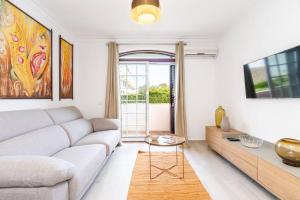 a living room with a couch and a table at TRÓIA BOUTIQUE APARTMENT in Troia