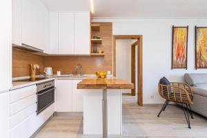 a kitchen with white cabinets and a wooden counter top at TRÓIA BOUTIQUE APARTMENT in Troia